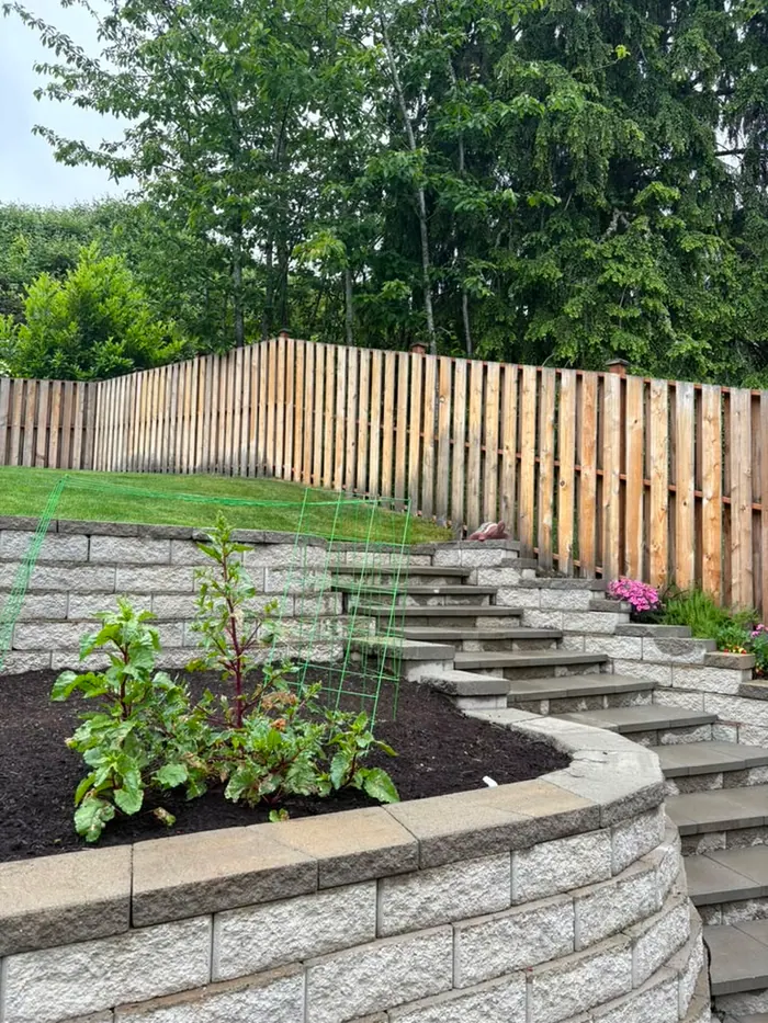 Before photo of fence along retaining wall before staining