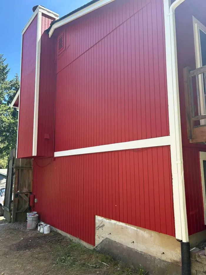 Close detail of red exterior siding with white trim after painting