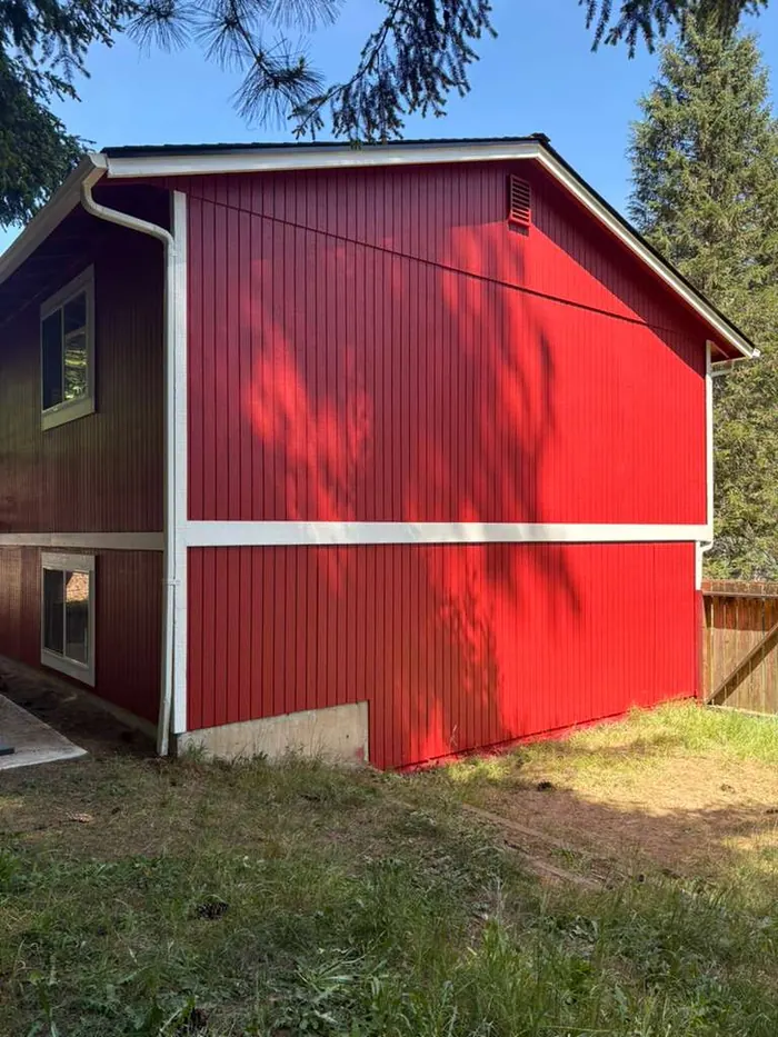 Side yard view of finished red exterior house painting project