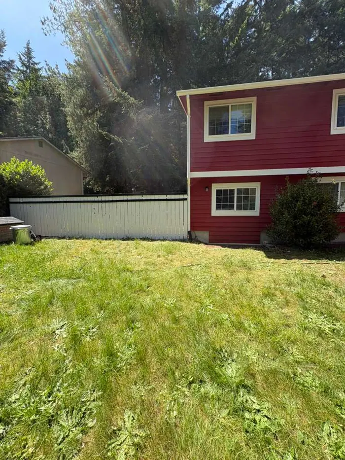 Backyard view of finished red exterior house repaint in Kitsap County