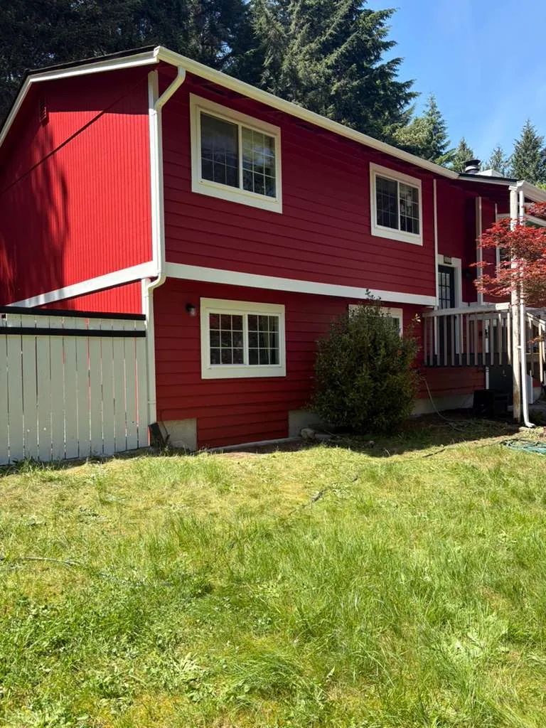 Completed red exterior house painting project with white trim